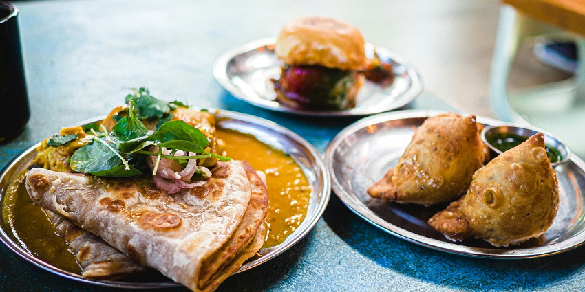 A mouth-watering view of a plate served with a variety of cooked vegetables and flatbread.