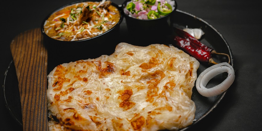 A lip-smacking view of a plate served with a cooked vegetable dish and flatbread.