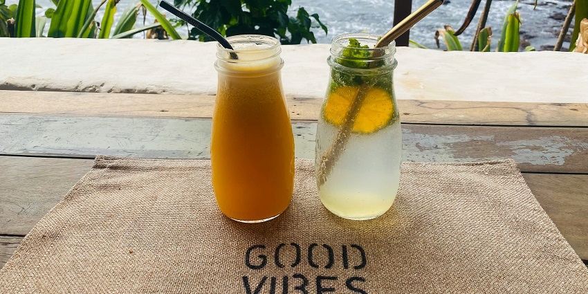 A mouth-watering view of glasses of mocktails sitting on top of a table during the day.