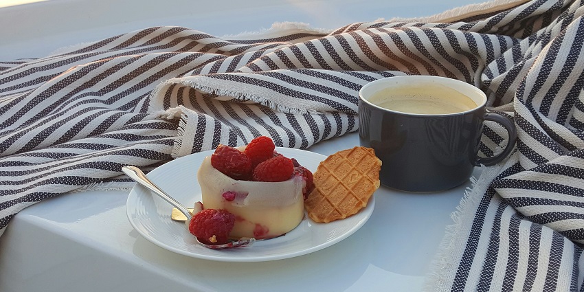 A mouth-watering view of a dish served on a white ceramic plate next to a cup of coffee.