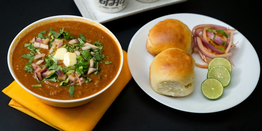 A mouth-watering view of a plate served with a cooked dish with a flatbread on the side.
