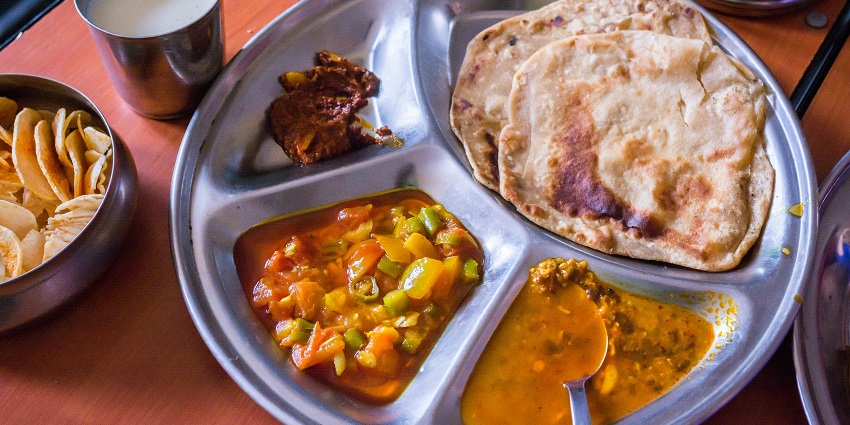 A tempting view of a plate served with different cooked vegetables and a flatbread.