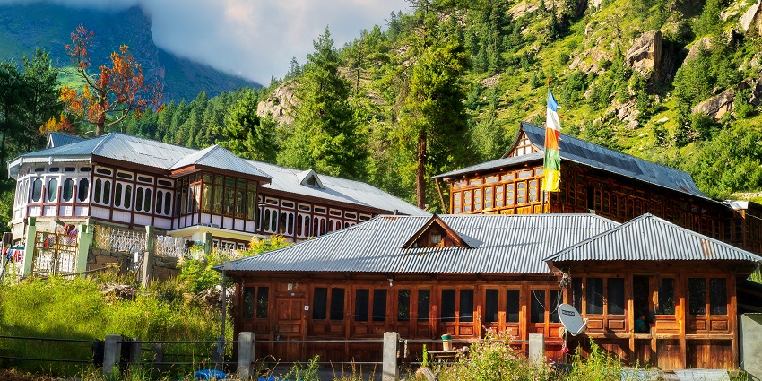 A breathtaking view of a colourful hotel in Himachal Pradesh surrounded by lush greenery.