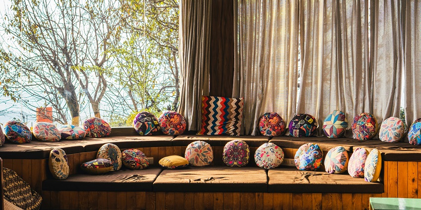 A fascinating interior view of a hotel in Himachal Pradesh with colourful cushions.