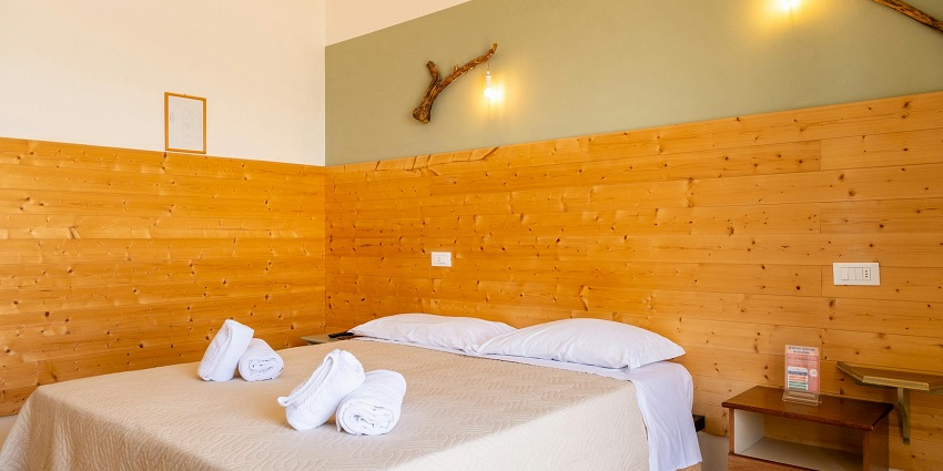 A stunning view of a bedroom with yellow walls and a bed lined with white sheets.
