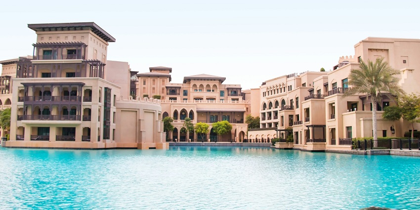 A breathtaking view of a hotel in Dubai with a pool in front during the daytime.