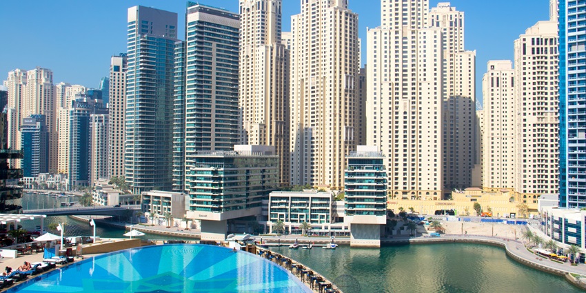 A breathtaking view of hotels in Dubai surrounded by water and lush green trees.