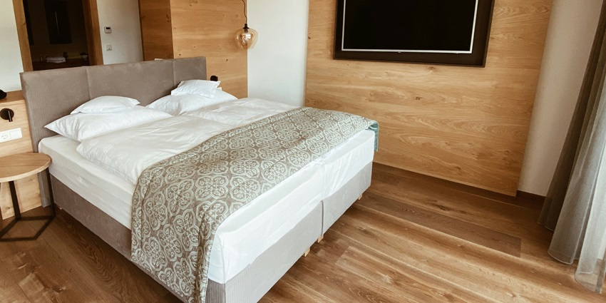 A mesmerising view of a bedroom with a brown bed lined with white sheets and pillows.