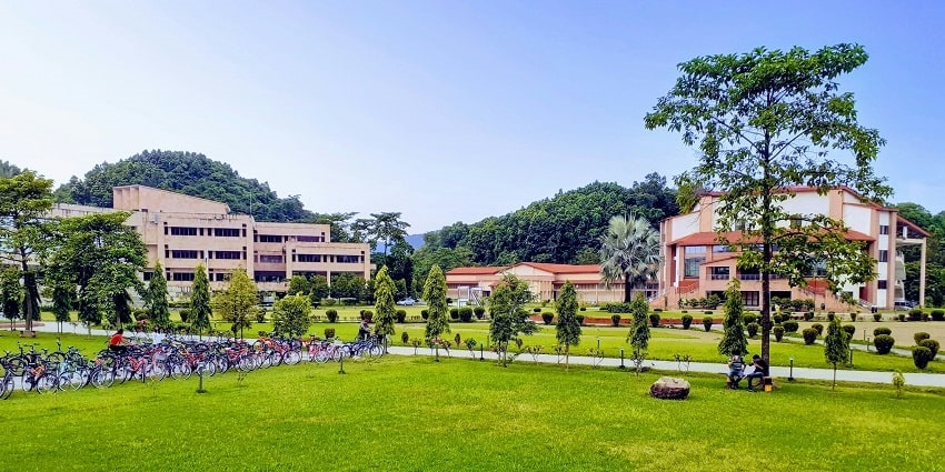 A stunning view of hotels with a green grass field in front of it during the daytime.