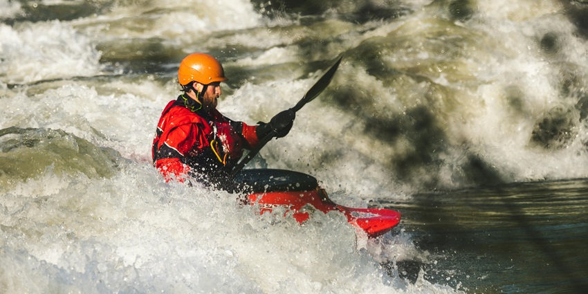 A rafting enthusiast passing through a high flowing river