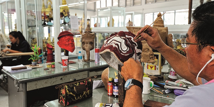 A picture of an artist creating a piece of art to sell it at the handicraft centre