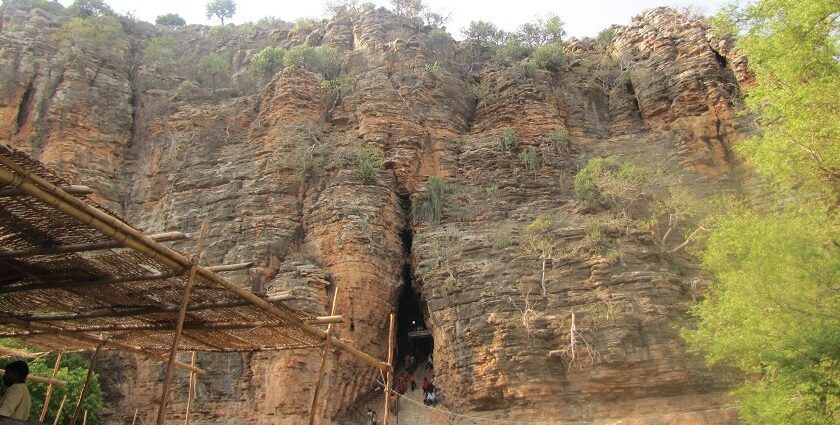 Scenic view of Yaganti Cave in Kurnool, surrounded by lush greenery and rocky hills.