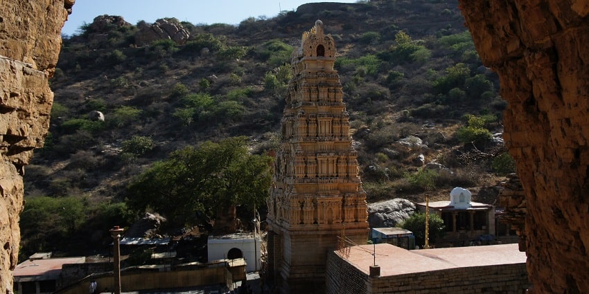 Image of Yaganti Temple in Andhra Pradesh, surrounded by lush green hills and rocks.