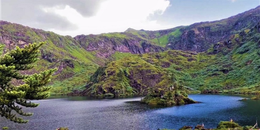 Beautiful snapshot of a lake amidst the green lush hill in the foothills of the Himalayas
