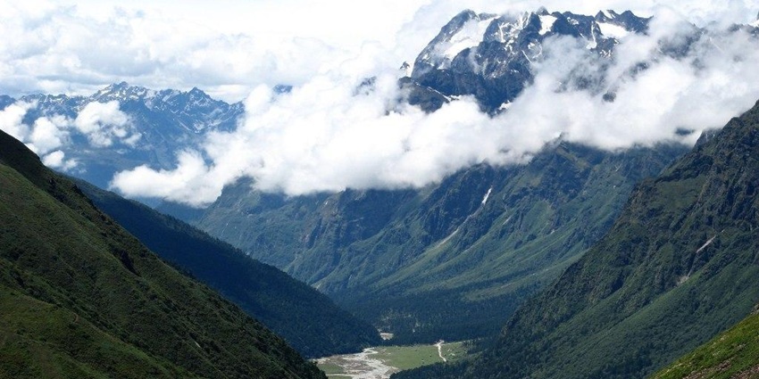 A breathtaking view of the Yumthang Valley featuring majestic mountains and greenery.