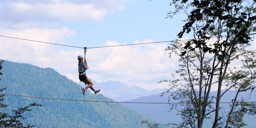 Adventure seekers ziplining across a scenic valley near Manali, enjoying a thrilling aerial view of the mountains.