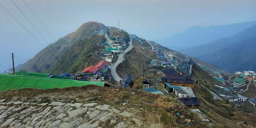 Misty dawn over the mountain village of Zuluk, with slopes fading into light