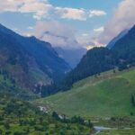 A mesmerising view of a lush green valley in Kashmir with mountains in the backdrop.