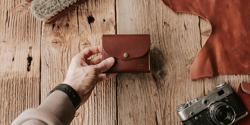 A table with a wallet kept on it with a camera and brush beside it. Cost of scuba diving.