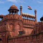 A breathtaking view of the Red Fort with a flag on top of it during the daytime.