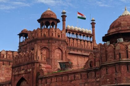 A breathtaking view of the Red Fort with a flag on top of it during the daytime.