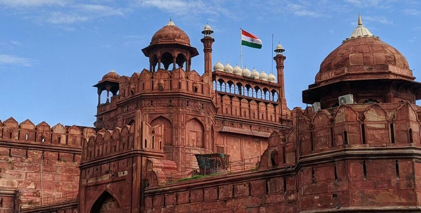 A breathtaking view of the Red Fort with a flag on top of it during the daytime.