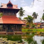 A breathtaking view of a red coloured temple on a body of water during the daytime.