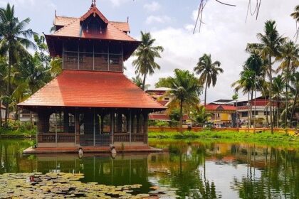 A breathtaking view of a red coloured temple on a body of water during the daytime.