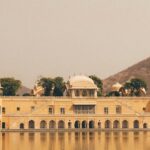 A serene view of a splendid palace surrounded by shimmering waters in Rajasthan.