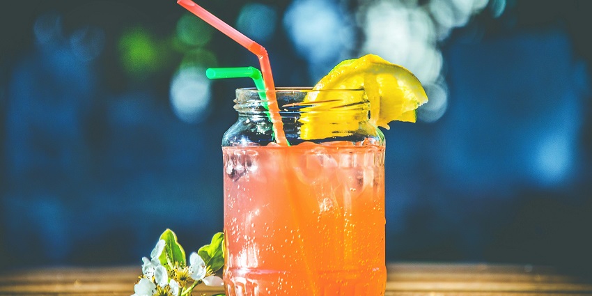 A close-up of vibrant pink liquid swirling in a clear glass, creating a mesmerising effect.
