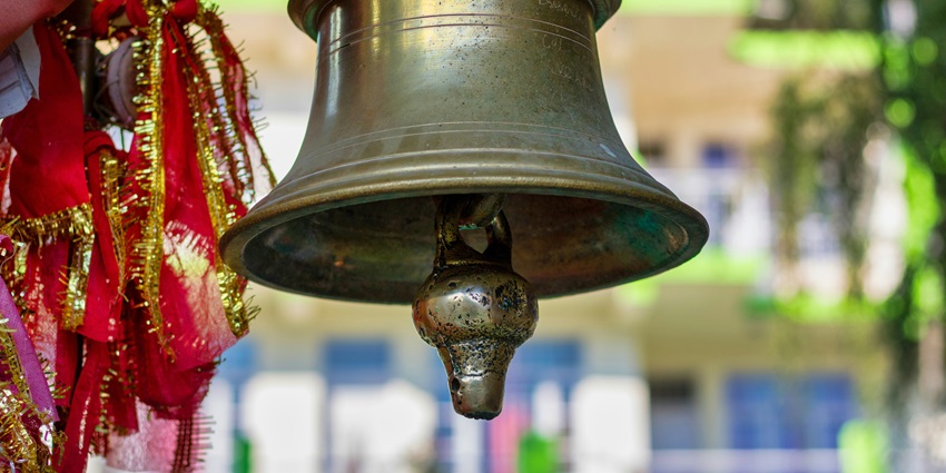 A close-up of a beautifully crafted temple bell in Dada Dev Mandir near Palam.