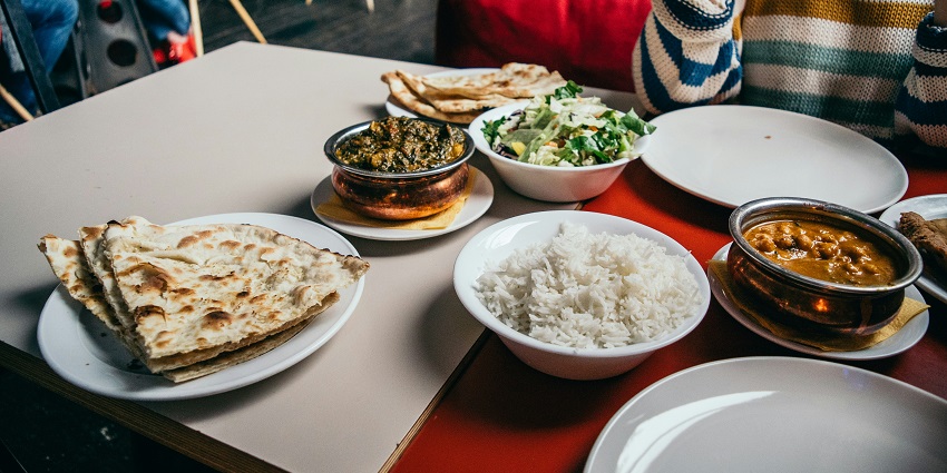 Image of a vibrant table full with an array of traditional Indian dishes.