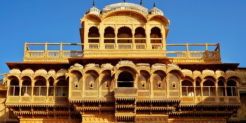 View of a grand, ancient palace featuring traditional arches, domes, and intricate stonework