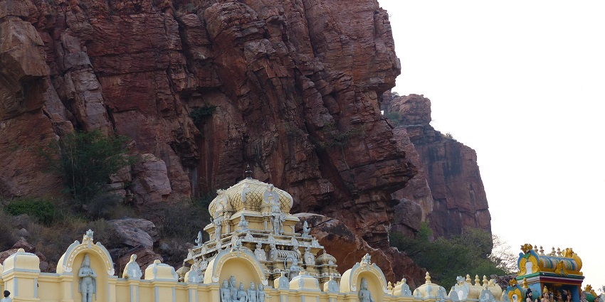 A picture of a temple in front of a cliff with traditional Hindu architecture and intricate designs