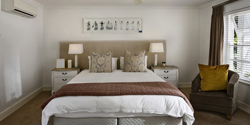 Cosy hotel room with a comfortable bed, stylish decor, and large windows with a view
