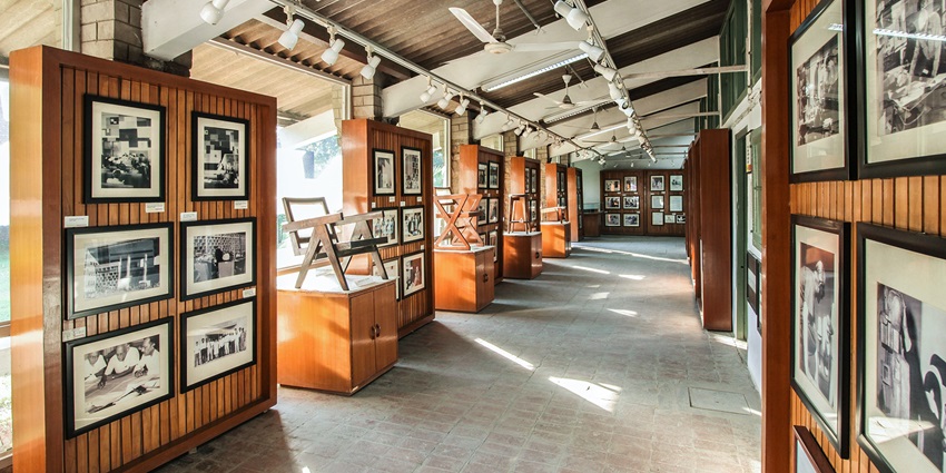 A picture of an art gallery with paintings on both sides of the walkway
