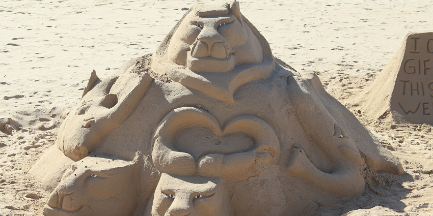 Elaborate reflection of a sandcastle on a beach in Odisha set against a sandy shoreline