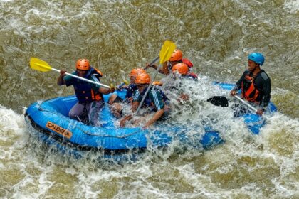 A breathtaking view of a few men enjoying river rafting in a body of water during the day.