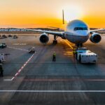 A quaint view of an aeroplane on the runway ready to fly with a picturesque backdrop.