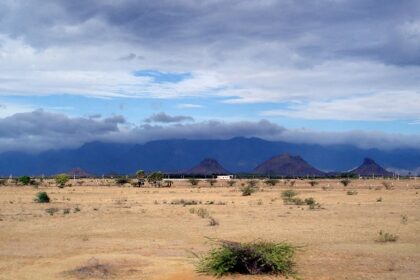 A picture of a scenic landscape of desert land and mountains in the background