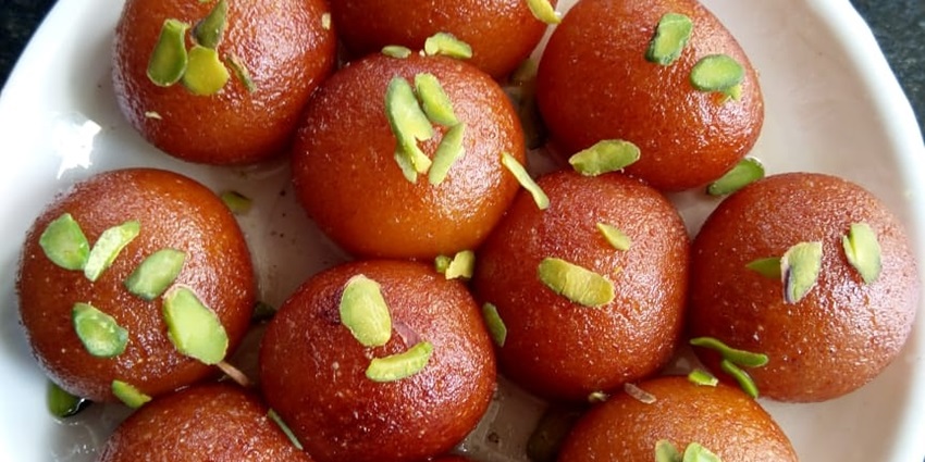 A plate of gulab jamun, sprinkled with pistas on the top, one of the locals favourite sweet