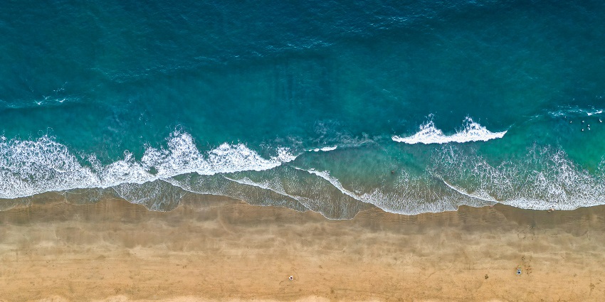 A bird’s eye view of cobalt blue waters meeting the rustic golden sands at Agonda Beach.