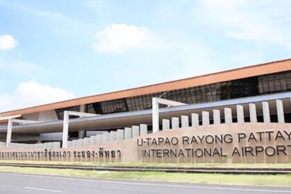 a frontal view of an airport with yellow architecture and bold letters during the daytime.