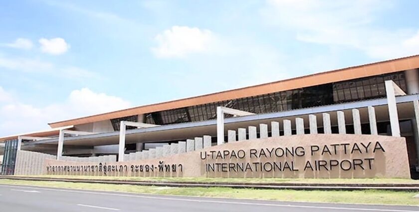 a frontal view of an airport with yellow architecture and bold letters during the daytime.