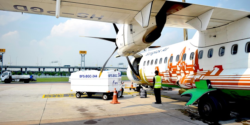 Image of an aircraft waiting at Suvarnabhumi with a van and man standing in front.