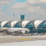 Breathtaking view of an airport with a plane around stunning architecture during the day.