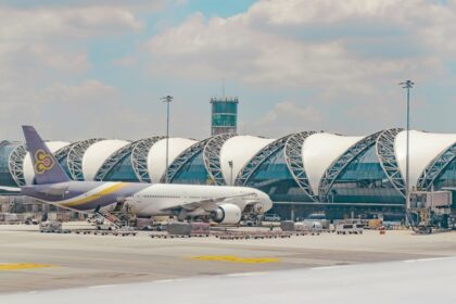 Breathtaking view of an airport with a plane around stunning architecture during the day.