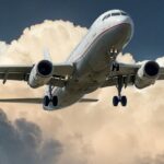 Breathtaking view of a red and white aeroplane surrounded by dense clouds during the day.