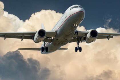 Breathtaking view of a red and white aeroplane surrounded by dense clouds during the day.