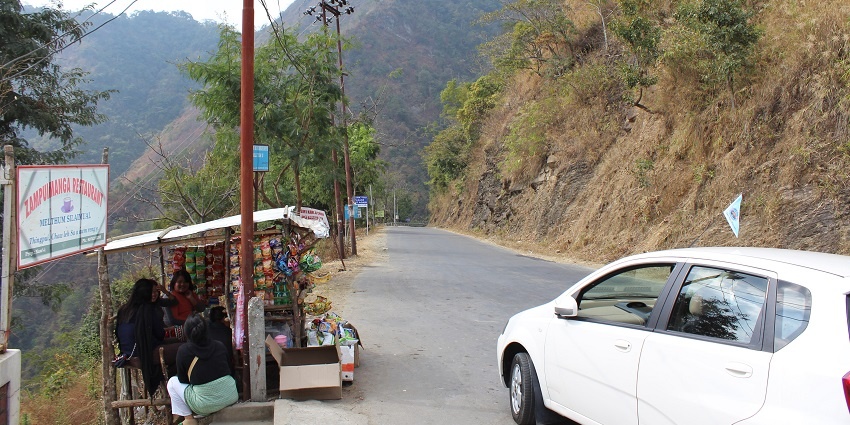 Image of twisty road in Aizawl, around the hills and small shop on the road side.